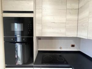 a kitchen with a stainless steel refrigerator and white cabinets at Intero Appartamento a Pescara in Pescara