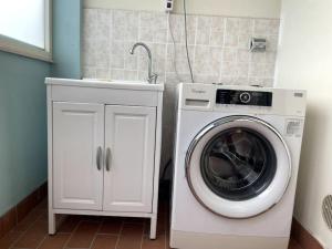 una lavatrice e un lavandino in bagno di Intero Appartamento a Pescara a Pescara