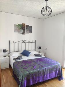 a bedroom with a large bed with a purple comforter at Mirador de los Amantes - VUTE-23-019 in Teruel