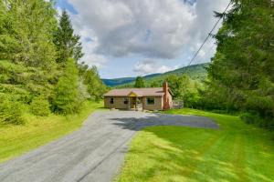 un camino vacío a una pequeña casa en el bosque en Quiet Catskills Getaway with Deck-Panoramic Mtn Views en New Kingston