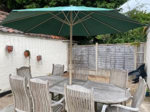 a wooden table with chairs and a green umbrella at Lincoln House in Lincoln
