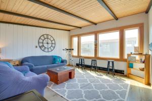 a living room with a blue couch and a table at Bandon Home with Patio, Steps to South Jetty Park in Bandon