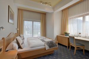 une chambre avec un lit, un bureau et une fenêtre dans l'établissement Appartementhaus Kostenzer, à Fügen