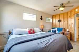 a bedroom with a bed and a ceiling fan at Bandon Home with Patio, Steps to South Jetty Park in Bandon