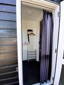 eine Tür, die in ein Zimmer mit einem lila Vorhang führt in der Unterkunft La Luna - Danny in Heerhugowaard