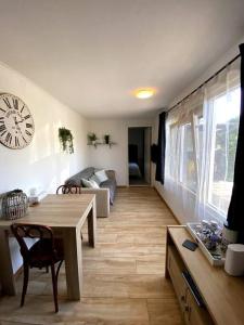 a living room with a table and a clock on the wall at La Luna - Danny in Heerhugowaard