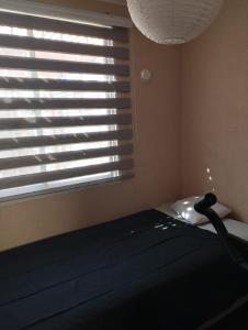a bedroom with a window with blinds on a bed at Acogedora y Central Casa in La Serena
