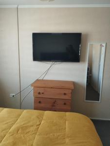 a bedroom with a flat screen tv on the wall at Acogedora y Central Casa in La Serena