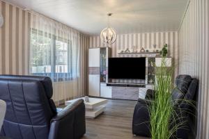 a living room with two chairs and a flat screen tv at Harmonie in Nordenham
