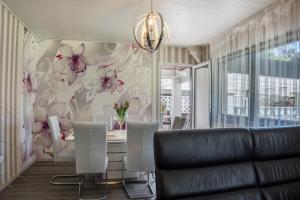 a dining room with a table and flowers on the wall at Harmonie in Nordenham