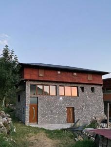 un gran edificio de piedra con puertas y ventanas en Shpija e Gjyshit Vuthaj, en Gusinje