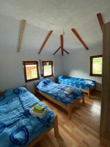 Habitación con 2 camas y 2 ventanas. en Shpija e Gjyshit Vuthaj, en Gusinje