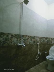 La salle de bains est pourvue d'une douche et de toilettes. dans l'établissement Defence Orchard DHA Karachi, à Karachi