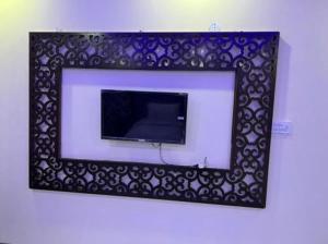 a mirror with a tv on a wall at Defence Orchard DHA Karachi in Karachi