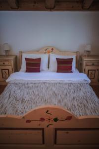 a bedroom with a large bed with red pillows at Cabana Bendis in Râşnov