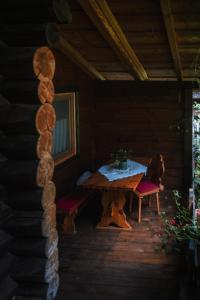 un porche de madera con mesa y sillas en una cabaña en Cabana Bendis en Rîşnov