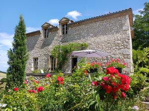 una casa de piedra con flores delante en LA MAISON FORTE en Montaut