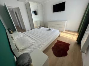 ein kleines Schlafzimmer mit einem weißen Bett und einem Spiegel in der Unterkunft Sky Residence Airport or Therme Spa no 10 in Otopeni