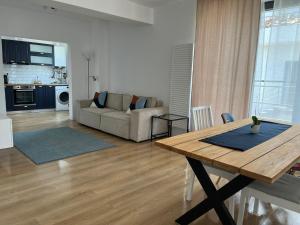 ein Wohnzimmer mit einem Tisch und einem Sofa in der Unterkunft Sky Residence Airport or Therme Spa no 10 in Otopeni