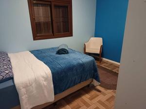 um quarto com uma cama, uma cadeira e uma janela em Casa na Serra Gaucha Canela em Canela