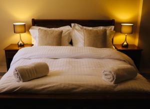 - un grand lit blanc avec des oreillers et 2 lampes dans l'établissement Dar Guéliz, à Marrakech