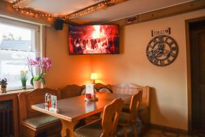 comedor con mesa y reloj en la pared en Gasthof Sonnental, en Winterberg