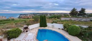 a house with a swimming pool on a hill at Villa Byala Grape House in Byala