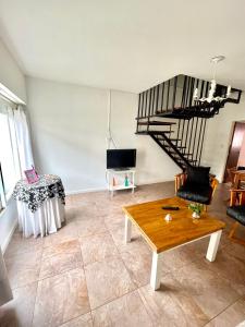 una sala de estar con una escalera de caracol y una mesa en Pepa en Tandil