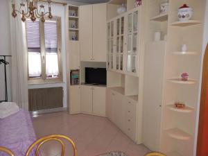 sala de estar con armarios blancos y TV en Geena's Home, en La Spezia