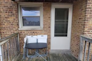 a porch with a chair and a refrigerator and a door at Great Chicago getaway 2 bedrooms Sleeps 1 to 4 in Chicago