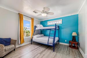um quarto com 2 beliches e uma ventoinha de tecto em Isla Bonita em Galveston