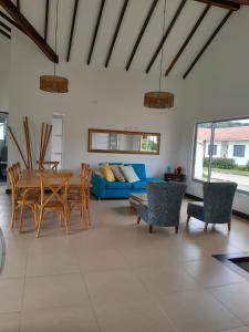 a living room with a table and a blue couch at CASA CAMPESTRE COMPLETa in Barbosa
