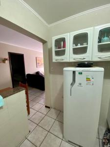 eine Küche mit einem weißen Kühlschrank im Zimmer in der Unterkunft Apto23 pérola - Nº 201 - A 150m Praia Grande in Ubatuba