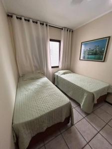 1 Schlafzimmer mit 2 Betten und einem Fenster in der Unterkunft Apto23 pérola - Nº 201 - A 150m Praia Grande in Ubatuba