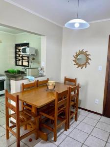 eine Küche mit einem Holztisch und einigen Stühlen in der Unterkunft Apto23 pérola - Nº 201 - A 150m Praia Grande in Ubatuba