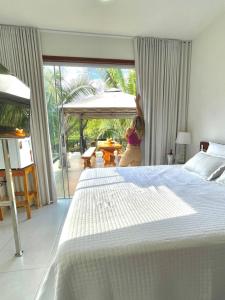 Hotel Villa Babaçu في جاكوبينا: طفل واقف في غرفة نوم بسرير كبير