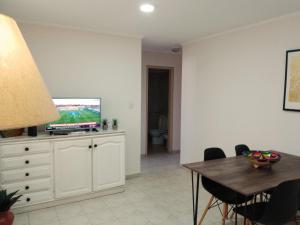 a living room with a television and a dining table at Nuevocentro 3 in Cordoba