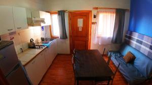 a small kitchen with a table and a dining room at Cabañas Hostel Aquario Papudo in Papudo