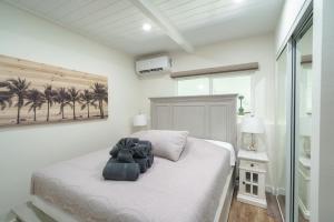 a bedroom with a white bed and palm trees at 401 Maalaea Banyans in Wailuku