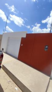 ein Gebäude mit zwei Garagentüren auf der Seite in der Unterkunft Casa em Barreirinhas in Barreirinhas