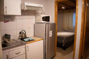 a small kitchen with a refrigerator and a microwave at Cabañas Hostel Aquario Papudo in Papudo