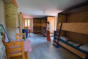 a woman standing in a room with bunk beds at Hostel Quartier Libre in Saint-Jean-en-Royans