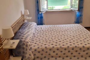 um quarto com uma cama com um cobertor florido e uma janela em Casa Baffo em Piombino