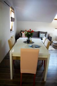 una sala da pranzo con tavolo e sedie bianchi di Timeless a Gospić