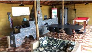 tavolo e sedie in una stanza con muro di mattoni di Sítio Chalé 3Ipes a Senador José Bento