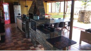 una cucina con piano cottura in pietra e tavolo di Sítio Chalé 3Ipes a Senador José Bento