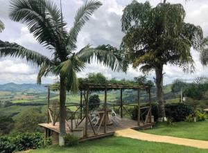 una palma e un ponte di legno con una palma di Sítio Chalé 3Ipes a Senador José Bento