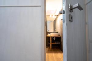 a door leading to a bathroom with a sink at casa vacanze Casa del Mare in Acitrezza