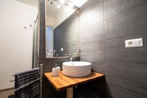 W łazience znajduje się umywalka i lustro. w obiekcie casa vacanze Casa del Mare w mieście Aci Trezza