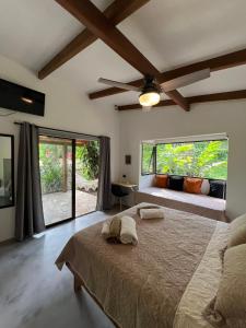 a bedroom with a bed and a large window at Feeling Trees Jungle Lodge in Cabuya